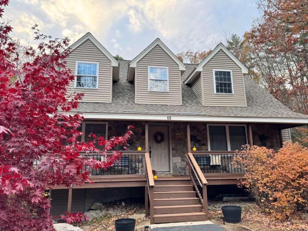 una casa con un ampio portico e una terrazza di Suissevale Lake Retreat - Hot Tub, Beach and Games ad Abbeyville