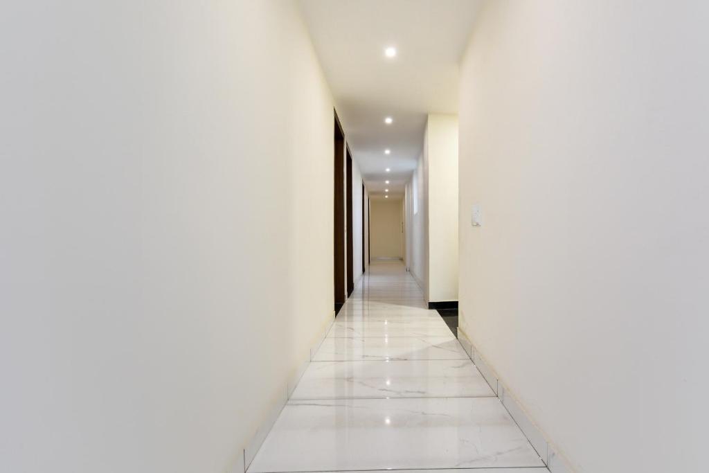 un pasillo vacío con paredes blancas y suelos blancos en Hotel O Park Land, en Zirakpur
