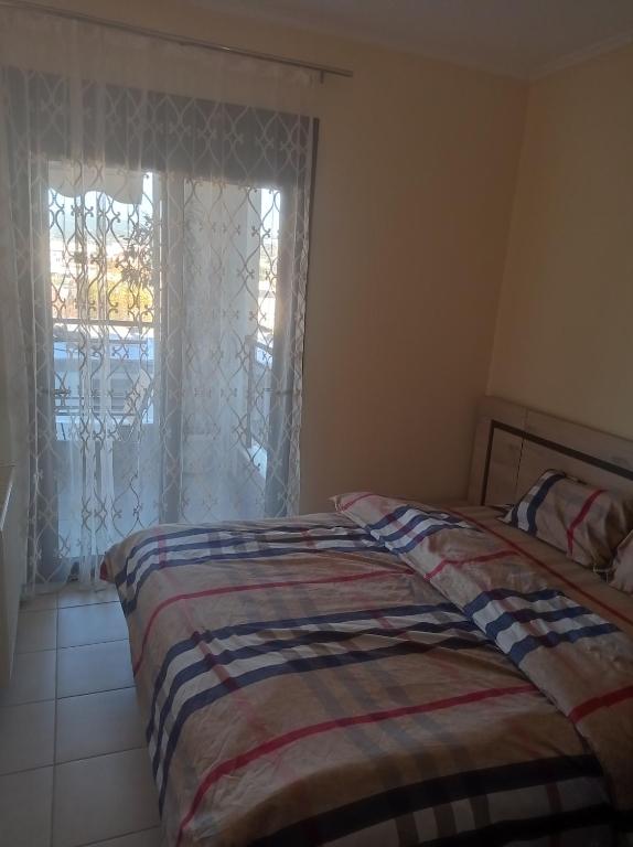Un dormitorio con una cama frente a una ventana. en Ζ Luxury near airport, en Tesalónica