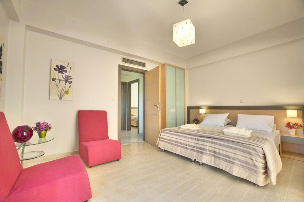 a bedroom with a bed and a red chair at Sirocco in Kissamos