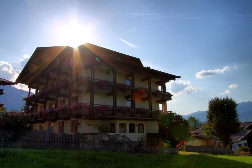 卡普伦Appartement 16 - Haus Voglreiter的阳光照耀下，阳台上鲜花盛开的建筑物