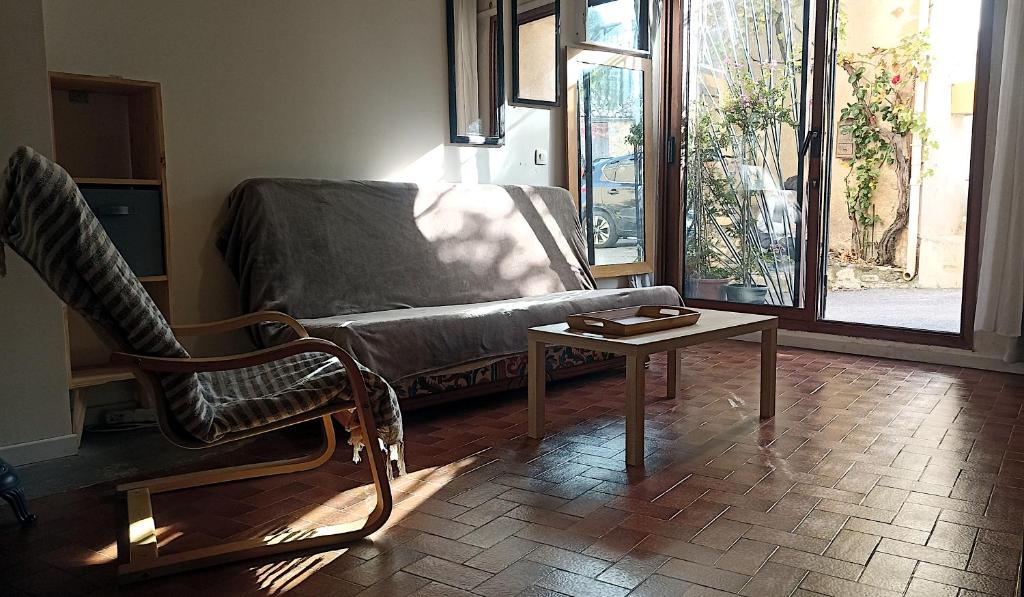een woonkamer met een bank en een salontafel bij Studio privé - maison de village in Valensole