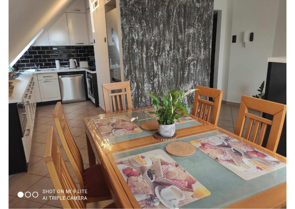 a dining room with a table and chairs and a kitchen at BJ szállás in Zalaegerszeg