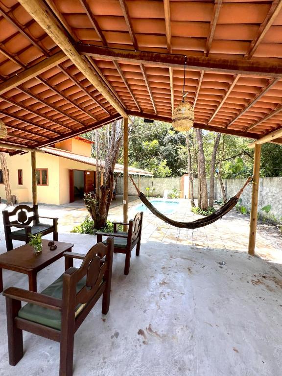 a hammock in a patio with two benches and a table at Pipa Moaina Hale in Pipa