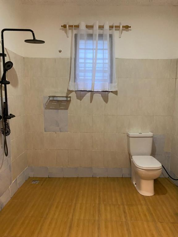 um banheiro com vaso sanitário e janela em Upendocozy villa em Praia de Diani