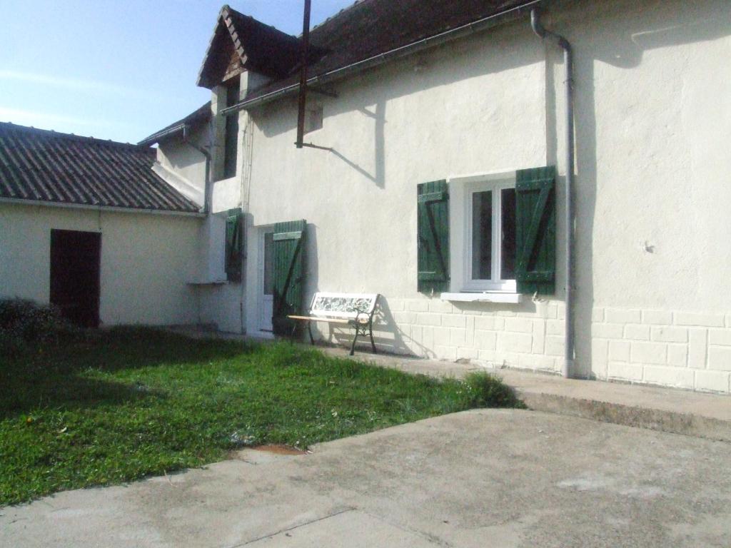 a white house with a bench in the yard at Chez Béa in Pleumartin