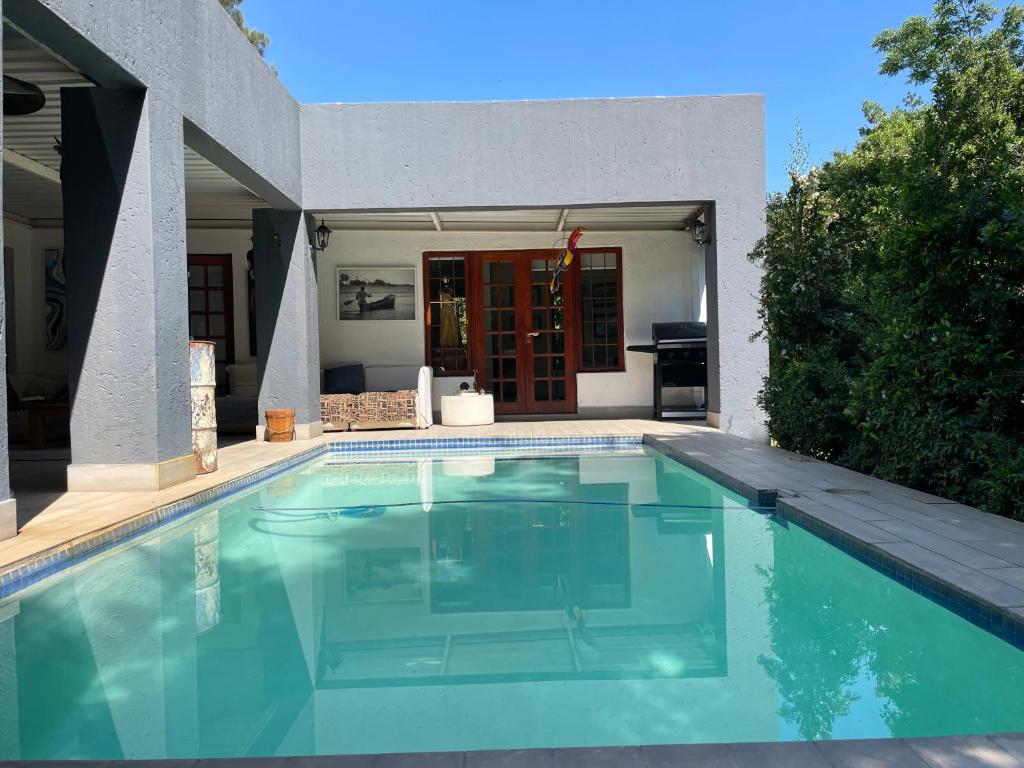 a swimming pool in front of a house at The Little Mongrel Deluxe Space Bryanston in Johannesburg