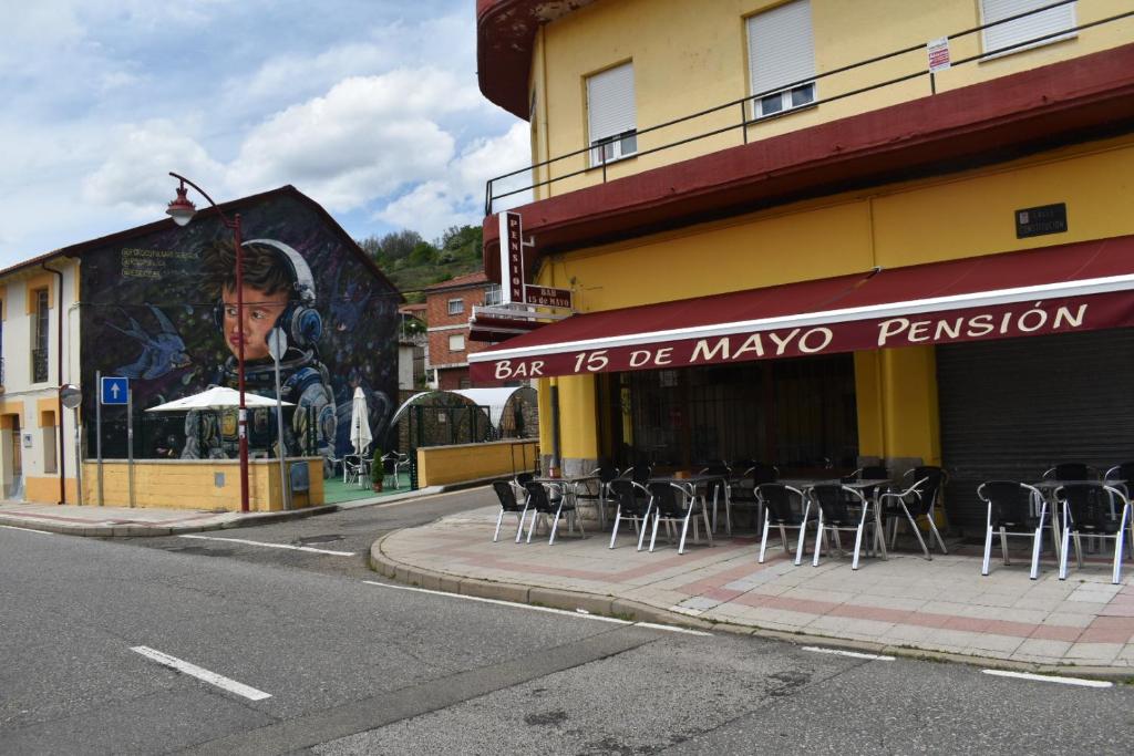 Eine Gruppe von Stühlen steht vor einem Gebäude in der Unterkunft Pensión 15 de Mayo in La Pola de Gordón