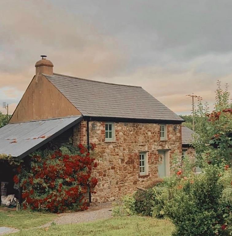 an old brick house with a black roof at The Little Welsh Cottage in Brynmenin