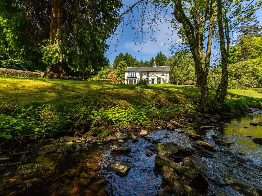 a house on a hill with a stream in front at Strathendrick House Magnificent property with Garden in Drymen