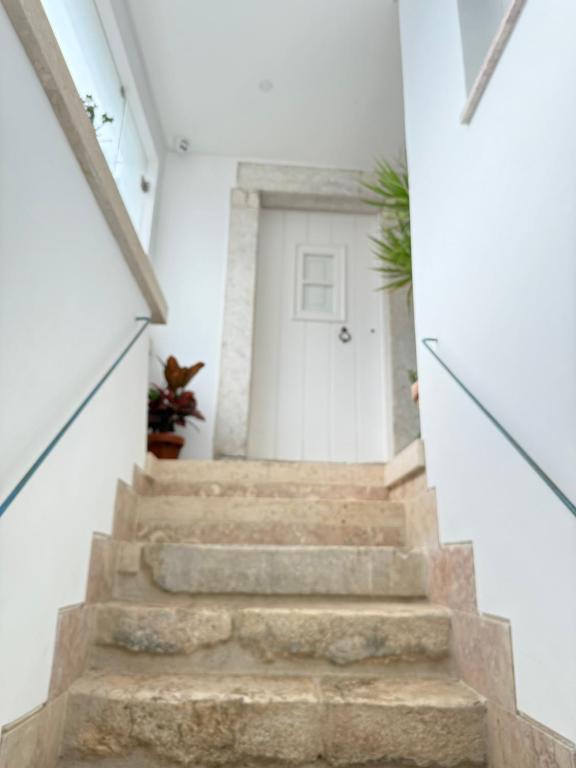 una escalera que conduce a una puerta blanca en Pátio Prior do Crato 4, en Almada