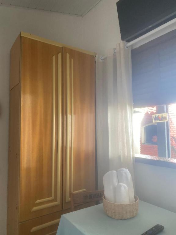 a kitchen with a wooden cabinet and a basket of towels at ElRancho Suites in Itaparica Town