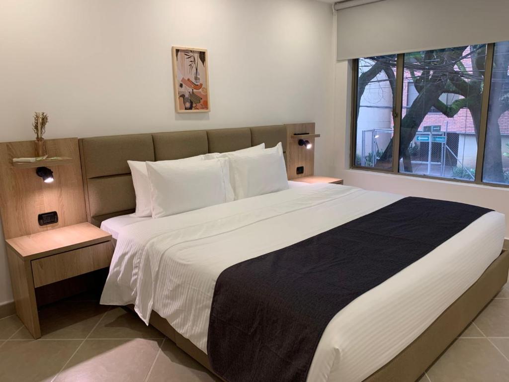 a bedroom with a large bed with a large window at Hotel Poblado Boutique in Medellín