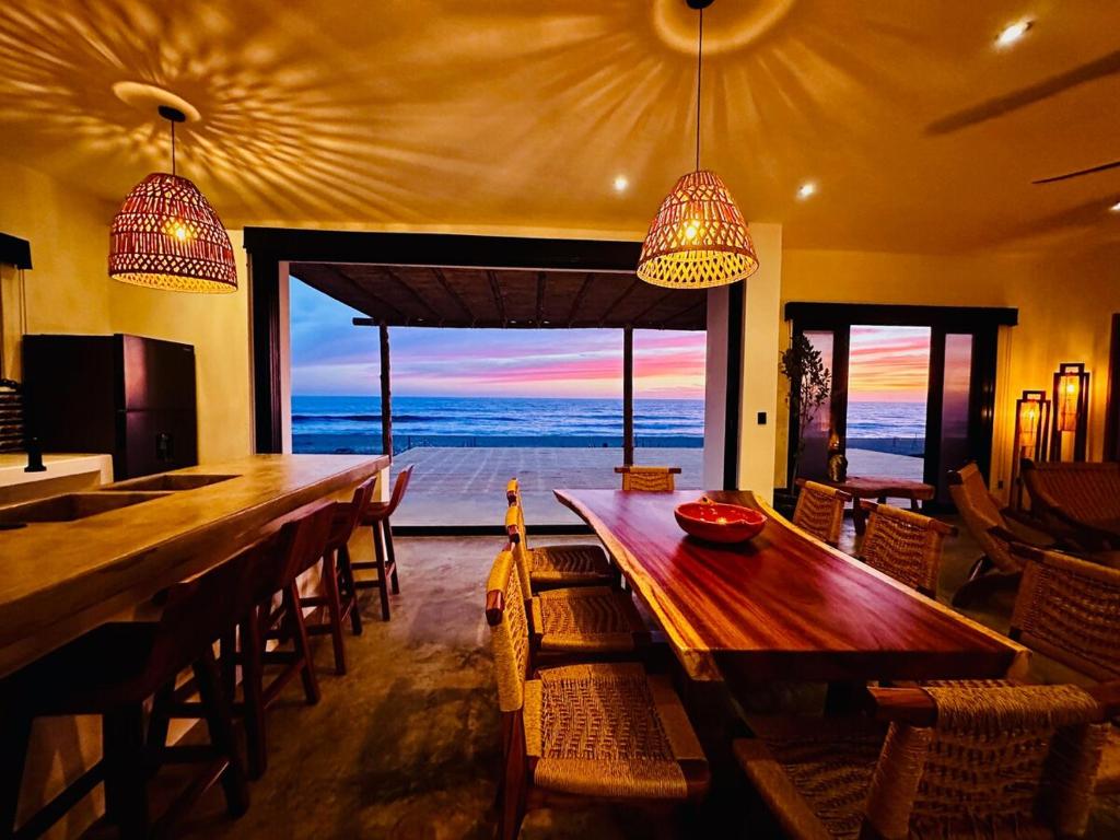 a dining room with a long wooden table and chairs at Casa Magica - A Baja Sur Beachfront Oasis in San Carlos