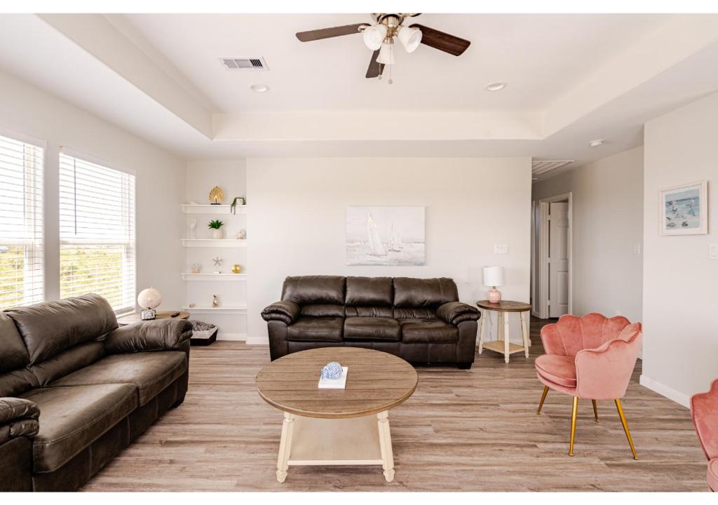 un salon avec un canapé et une table dans l'établissement Sunset Bellini with Hot Tub and Golf Cart!, à Bolivar Peninsula