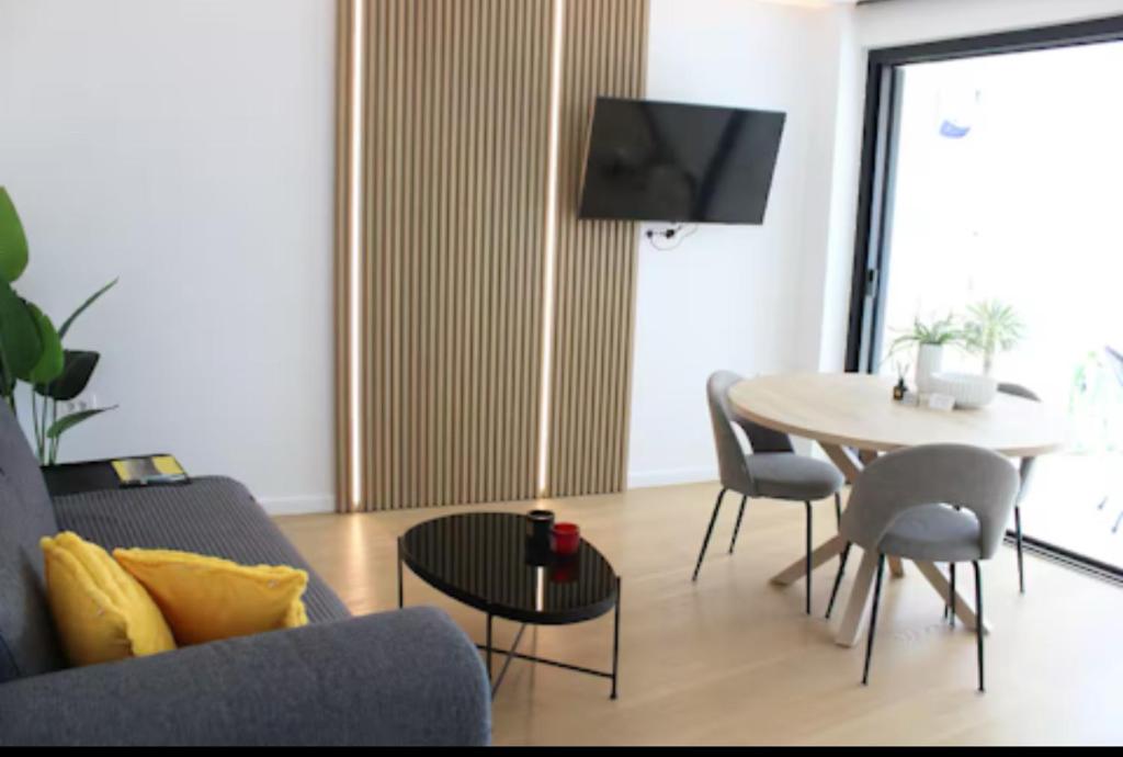 una sala de estar con un sofá y una mesa en LuxApart74 l Comfy & Minimal Stay in Ierapetra, en Ierápetra
