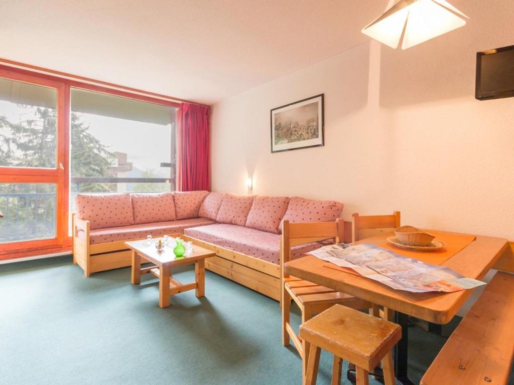 ein Wohnzimmer mit Sofa und Tisch in der Unterkunft Appartement 6 pers. au centre, balcon, wifi gratuit - FR-1-346-408 in Arc 1800