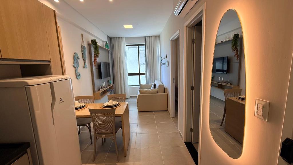 a kitchen and living room with a table and a dining room at Flat 1 quarto Beach Porto - By Duuna Temporada in Porto De Galinhas