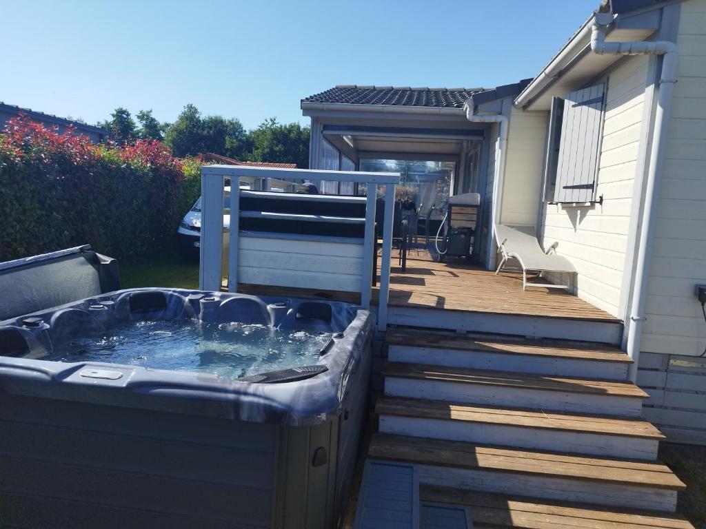a hot tub on a deck next to a house at Chalet in Hudimesnil