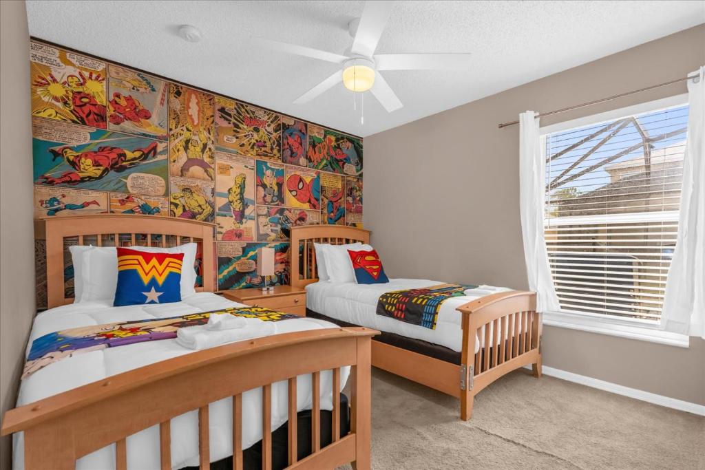 een slaapkamer met 2 aparte bedden en een muurschildering bij Summer Getaway - 5-Bedroom Home with Private Pool! in Kissimmee