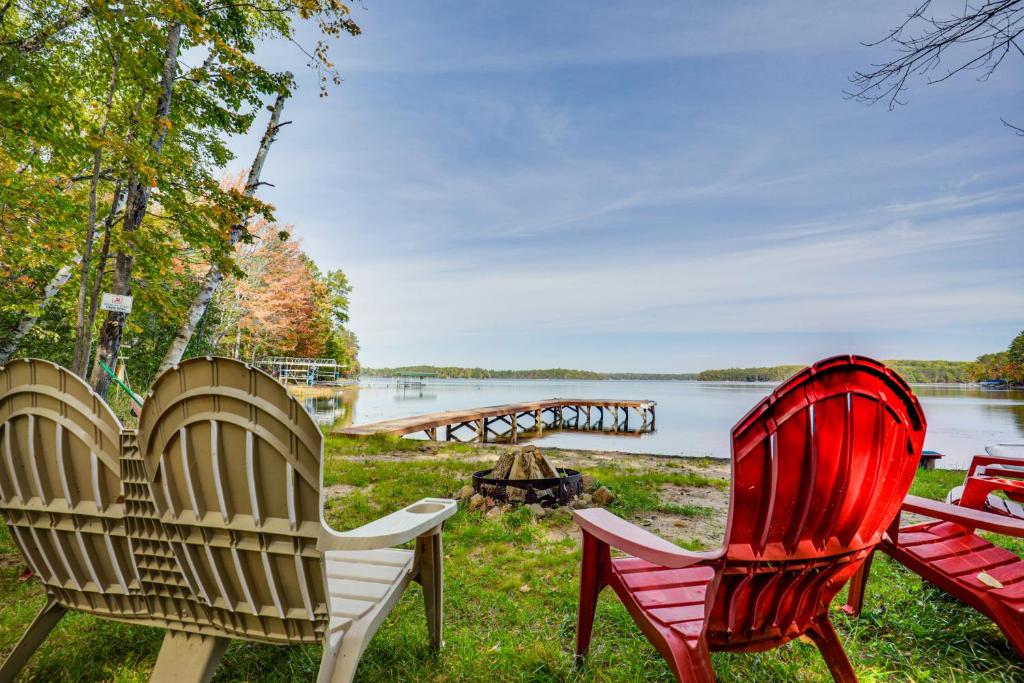 two red chairs sitting next to a body of water at Big Portage Lakefront Home: Boat, Swim & More in Land O' Lakes