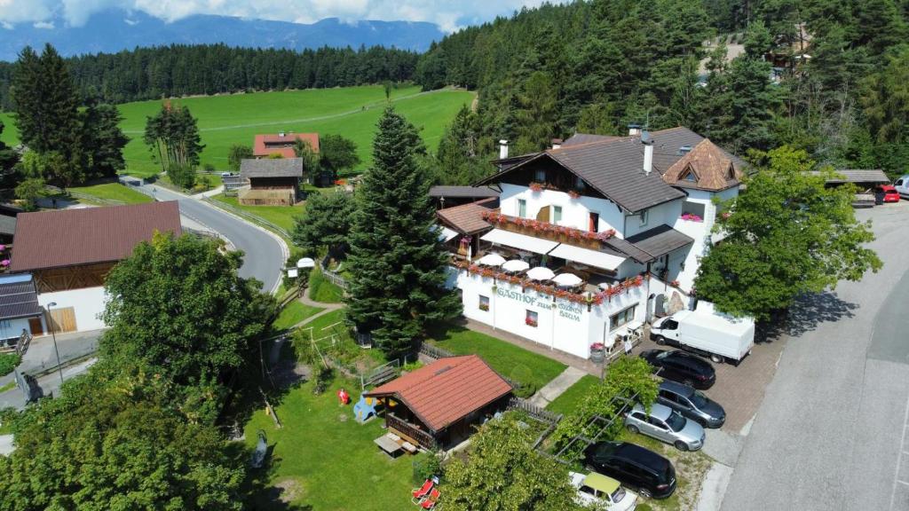 eine Luftansicht eines großen Hauses mit geparkten Autos in der Unterkunft Grunen Baum - Vöran in Vöran