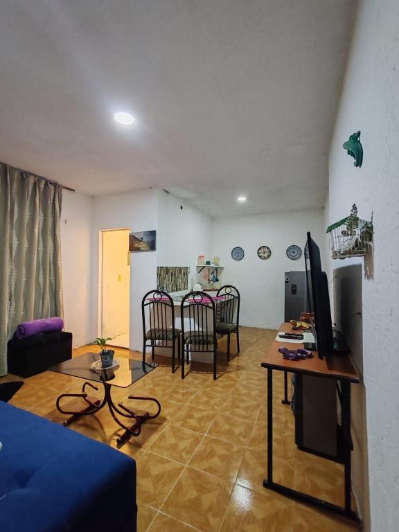 Una sala de estar con un sofá azul y una mesa. en Abuelita, en Santa María Tonantzintla