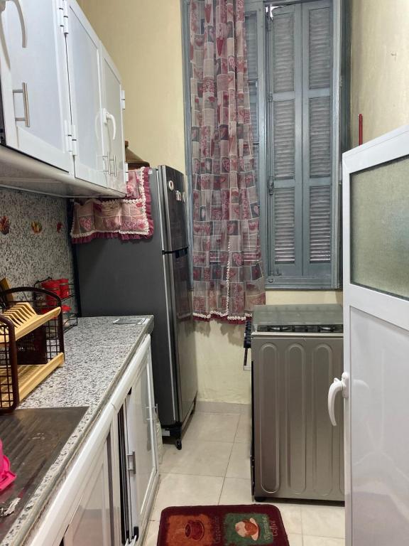 Una cocina con refrigerador de acero inoxidable y ventana. en Medina Tangier, en Tánger