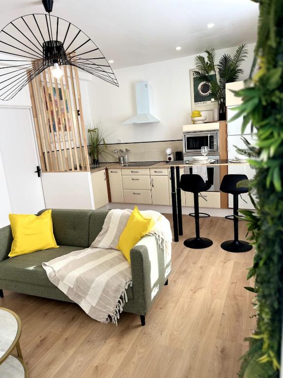 een woonkamer met een groene bank en een keuken bij L'Oxygène -400m de la gare in Saint-Brieuc