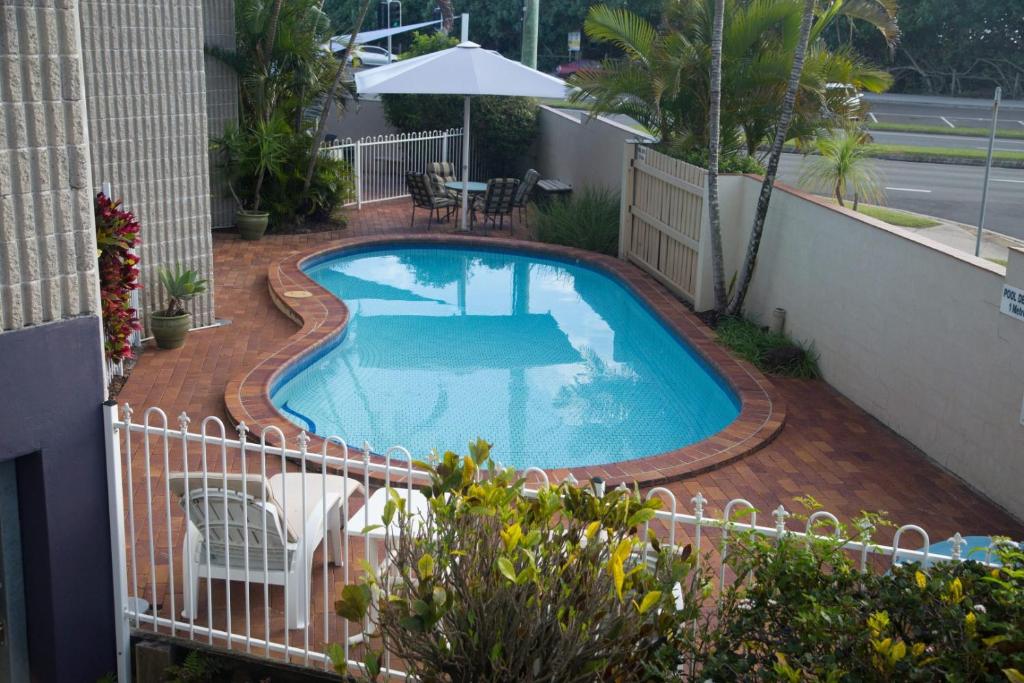 una piscina en un patio con una valla en Northpoint Holiday Apartments, en Alexandra Headland