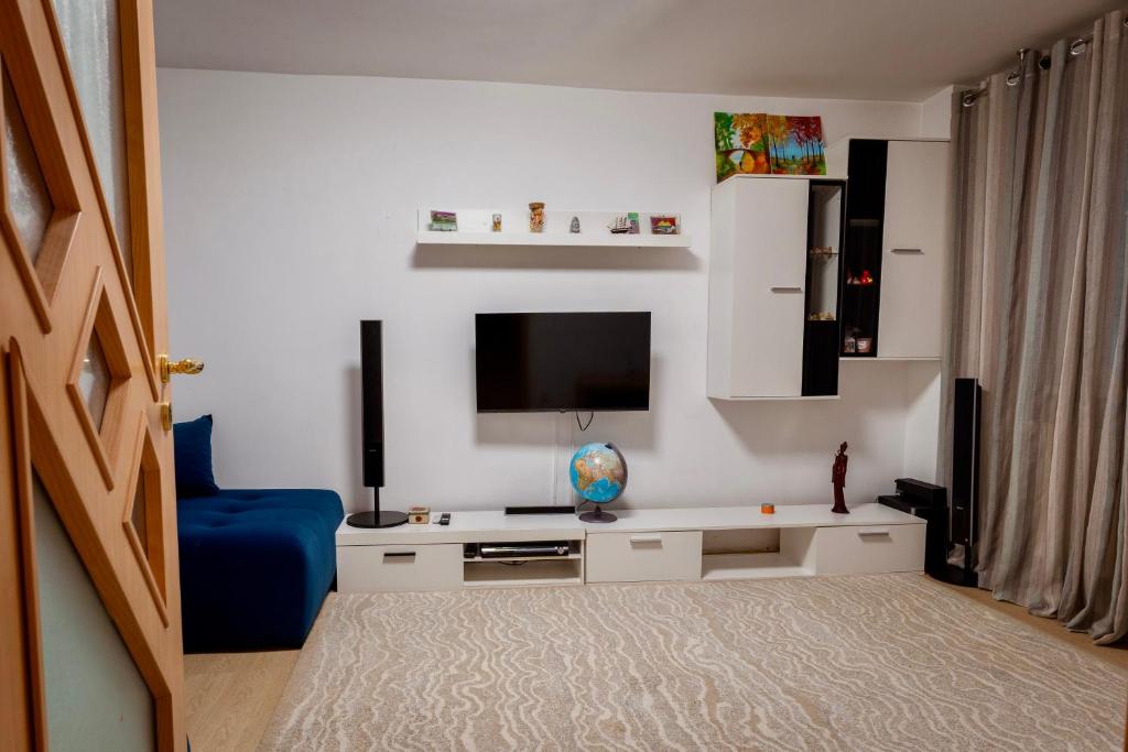 ein Wohnzimmer mit Fernseher und blauem Sofa in der Unterkunft Central Apartment in Bukarest