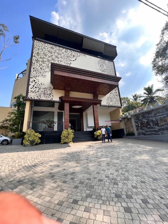two people standing in front of a building at Avanee Hotel in Mawanella