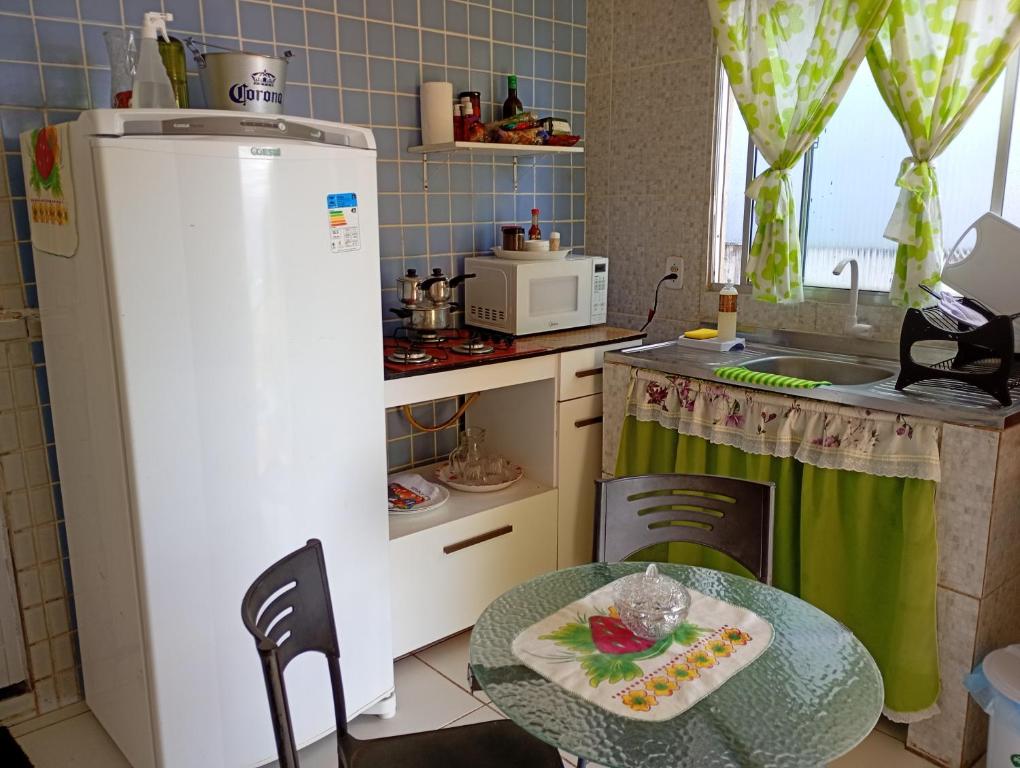 a small kitchen with a table and a refrigerator at Flat sol de Noronha in Fernando de Noronha
