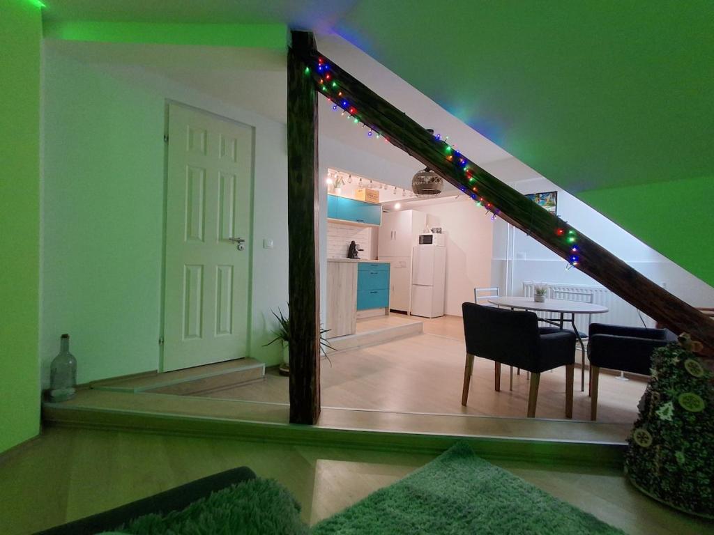 a room with a staircase with a table and a kitchen at KissApartman in Kőszeg