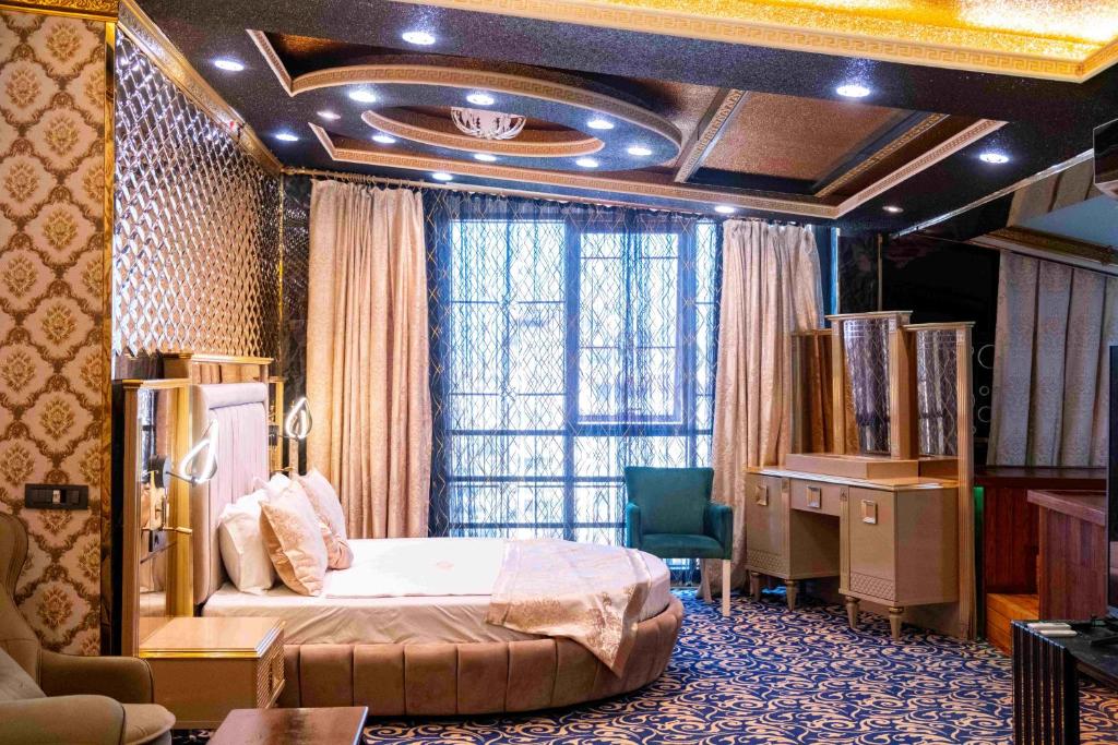 a bedroom with a bed and a desk and a window at can palace adalya otel in Antalya