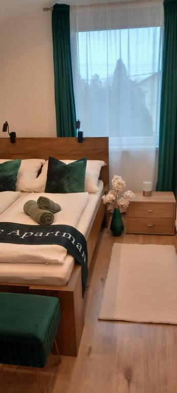 ハイドゥソボスローにあるWhite Stone Apartmanのベッドルーム1室(ベッド2台付)、緑のカーテン付きの窓が備わります。