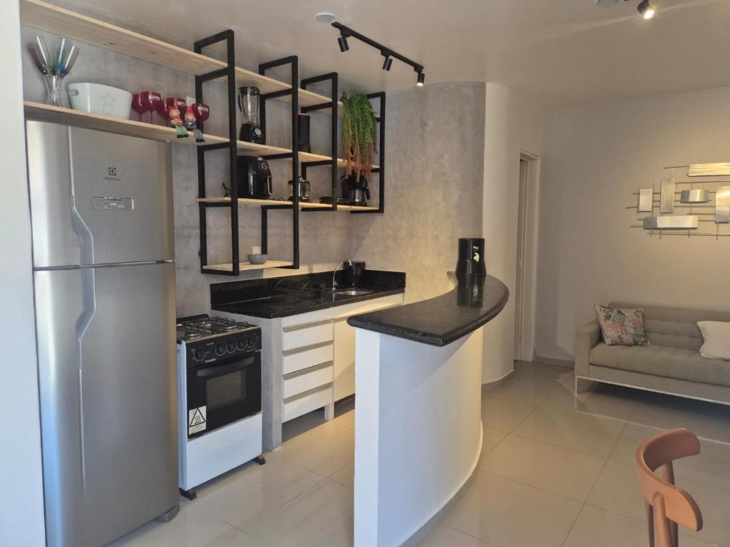 a kitchen with a refrigerator and a counter top at Pousada Villa Uçá Frances - Praia do Frances in Praia do Frances