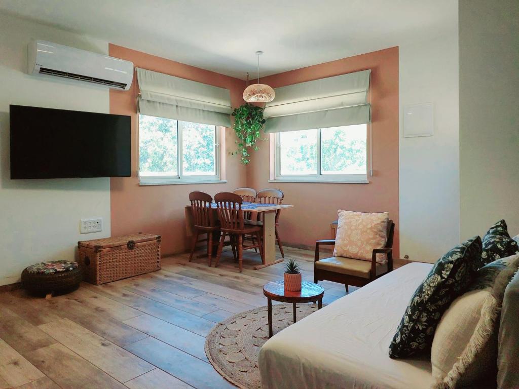 un soggiorno con divano e sala da pranzo di בדרך לנחל a Sde Nehemia