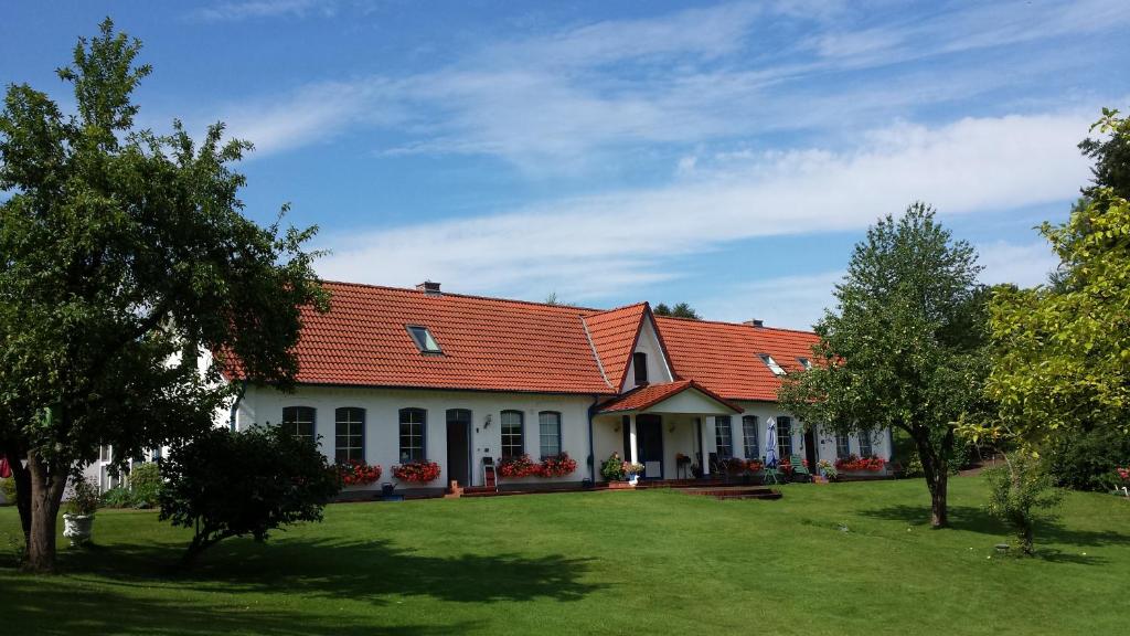 een huis met een oranje dak en een tuin bij Landhaus Freche Socke in Buchhorst