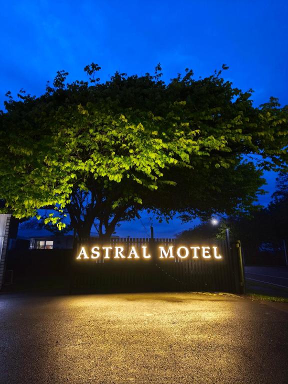 a sign that readsatal motel in front of a tree at Astral Motel in Whanganui