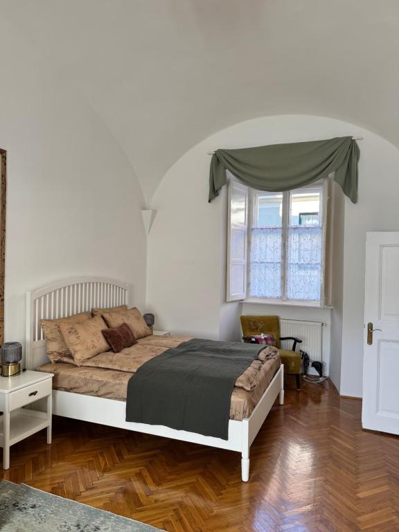 a bedroom with a large bed and a window at Forst Apartman in Eger