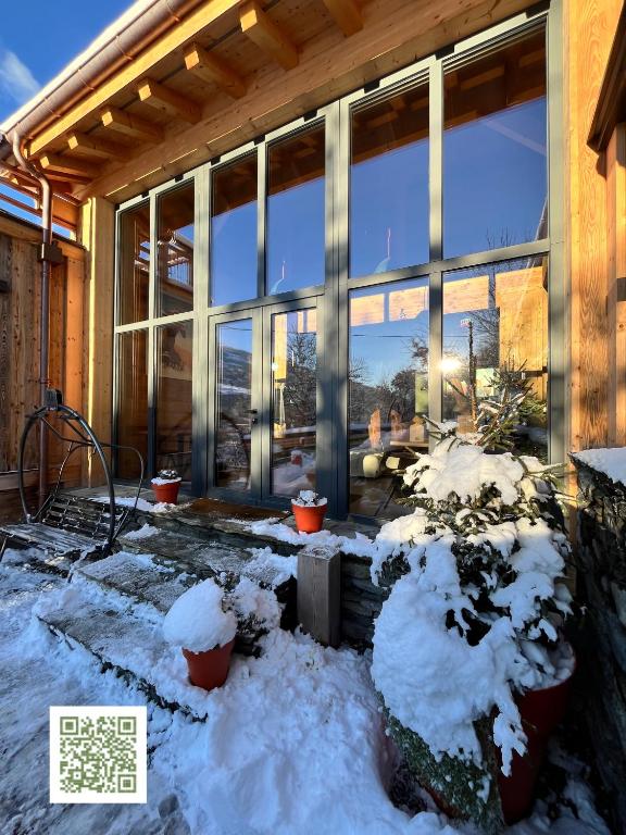 un edificio con nieve en el suelo y ventanas en La Grange des Eulets, en Bourg-Saint-Maurice