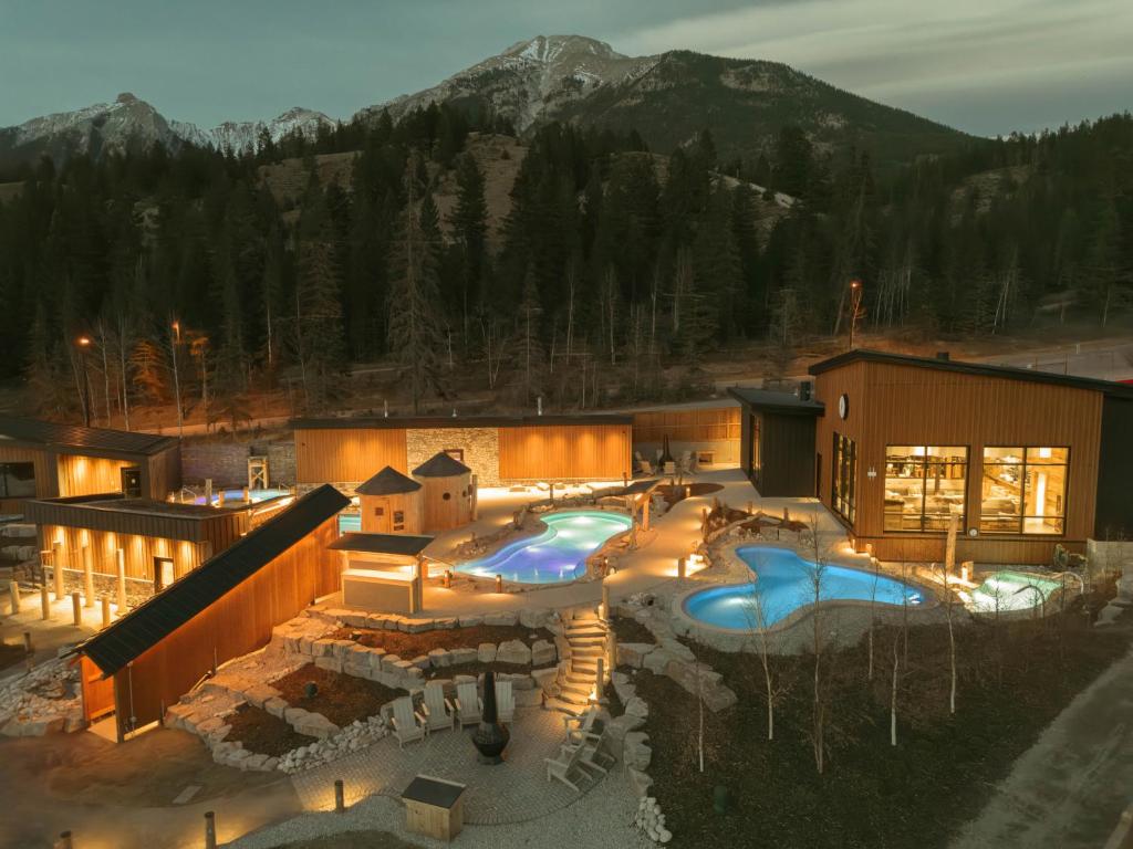 a resort with a swimming pool in front of a mountain at Everwild Canmore - Nordic Spa & Hotel in Canmore