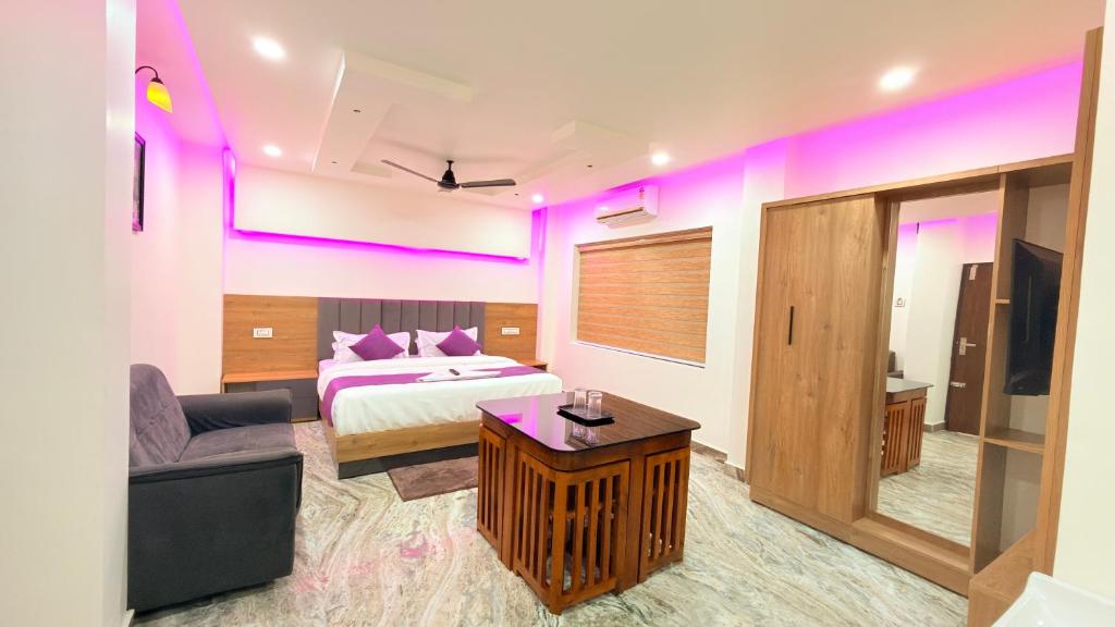 a bedroom with a bed and a couch and a table at Marhaba plaza in Kozhikode