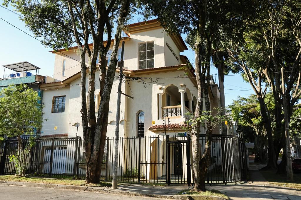una casa bianca con una recinzione e alberi di Casa del Viento 101 a Cali