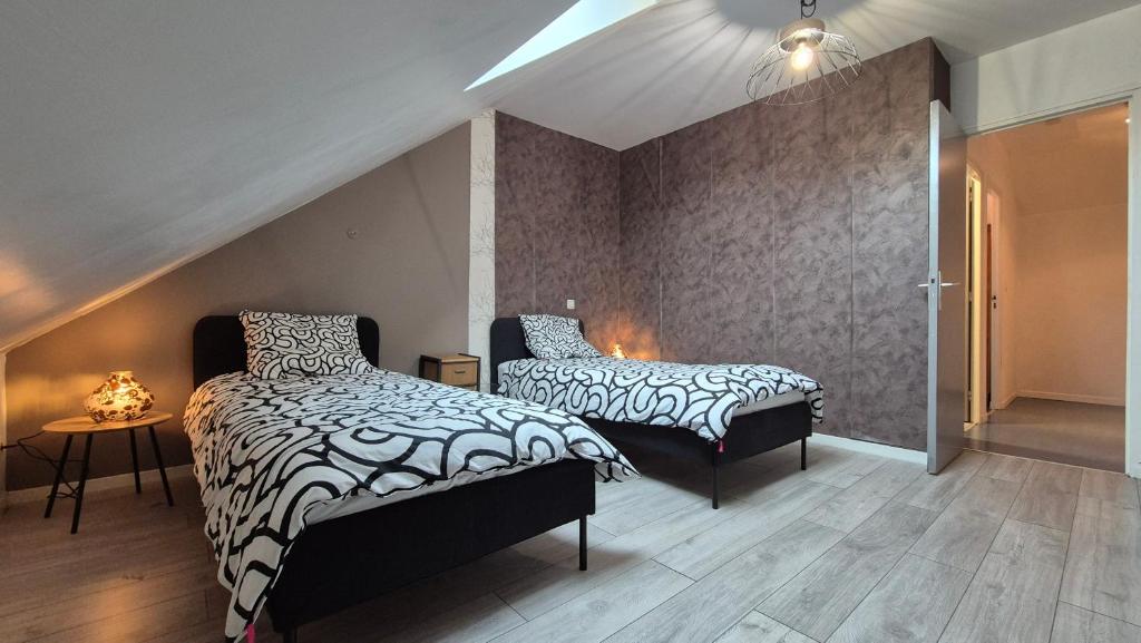 a bedroom with two beds and a staircase at Gites Le Roosevelt - Côte 204 in Château-Thierry