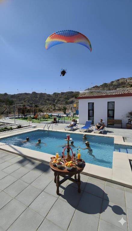 a paraglider flying over a swimming pool at شاليه منتجع جوري حتا الخاص -J4- Jory Hatta Private Resort Chalet in Hatta