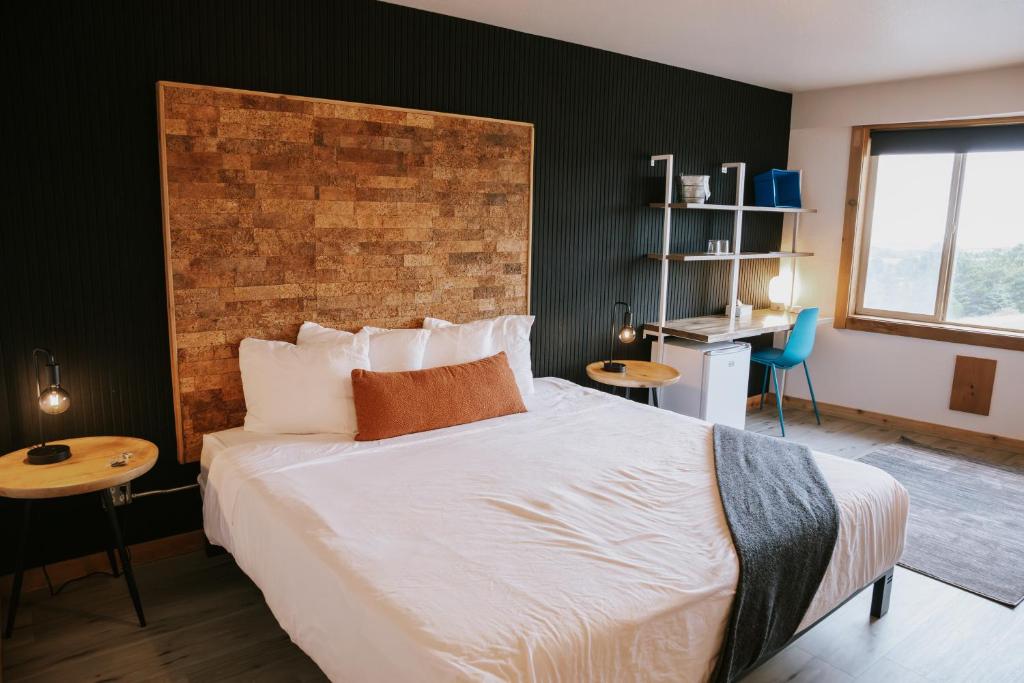a bedroom with a large bed with a brick wall at Adrift Hotel in Long Beach