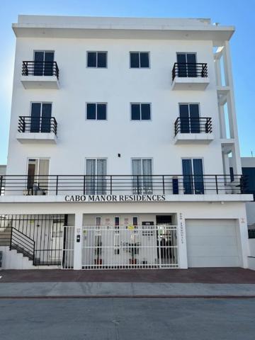 a large white building with a gate in front of it at Cabo Condos - Boutique Condos in Cabo San Lucas