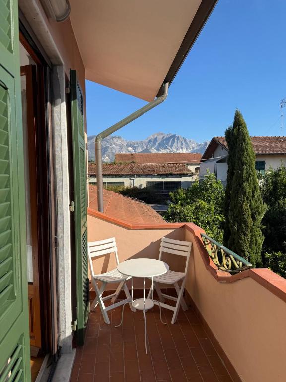 a patio with a table and chairs on a balcony at Joe's apartments in Carrara